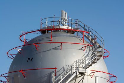 Esfera industrial de armazenamento de gás cercada por uma escada metálica