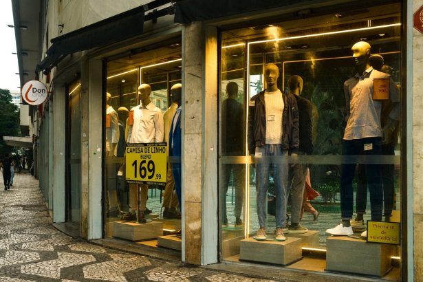 Interior de uma loja de moda masculina em São Paulo, com manequins e peças expostas na vitrine.